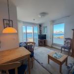 Living area with dining space, TV, and water view.