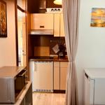 Kitchen with wooden cabinets, microwave, and washing machine.