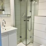 Badezimmer mit Dusche, Waschbecken und Spiegel