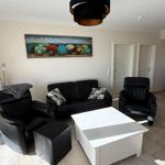 Living room with black seating, white table, and wall art with colorful umbrellas.