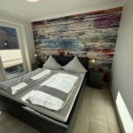 Bedroom with double bed, colorful wall mural, and window to terrace.