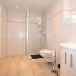 Bathroom with shower, toilet, and sink.