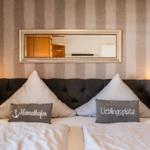 Double bed with pillows and mirror on the wall