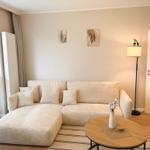 Living room with corner sofa, round table, and floor lamp.