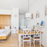 Bedroom with bed and dining area with table and chairs.
