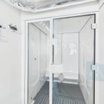 Steam room with glass door and control panel on the wall