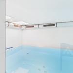 Indoor pool with white walls and ceiling vents.