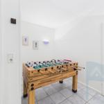 A foosball table is in a room with white walls and tiled floor.