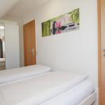 Schlafzimmer mit Bett, Wandbild und Tür