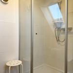 Dusche mit Glaswand, Duschbrause und Duschsitz