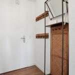 Eingangsbereich mit weiße Tür, Holzfußboden und Spiegelschrank mit Körbchen.
