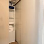 Schrank mit offenen Regalen, darin Handtuchstapel und blauer Korb.