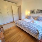Schlafzimmer mit Doppelbett, Kleiderschrank und Holzboden.