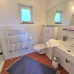Badezimmer mit Dusche, Toilette, Waschbecken und Heizkörper