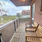 Terrasse mit zwei Holzstühlen und Blick auf Grünfläche und Gebäude