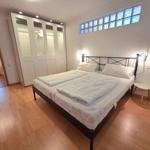 Bedroom with double bed, wardrobe, and floor window