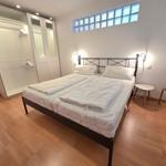 Bedroom with double bed, wardrobe, and glass window