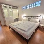 Bedroom with double bed, wardrobe, and hardwood floor.