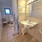 Bathroom with shower, sink, and toilet. Equipped for wheelchair access.