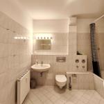 Modernes Badezimmer mit Badewanne und hellem Fliesenspiegel in Koserow