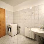 Sauberes Badezimmer mit Waschbecken und integrierter Waschmaschine