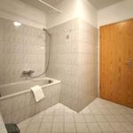 Weiß gefliestes Bad mit Badewanne für entspannte Urlaubsstunden