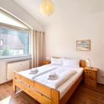 Behagliches Hauptschlafzimmer mit großem Doppelbett und Balkonzugang