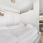 Bedroom with double bed, TV, and view of green field.