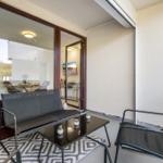 Terrace with seating and view into the house. Glass door and rug visible.