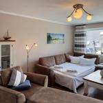 Living room with sofa bed, table, and view of rooftops