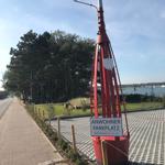 Straßenschild Inselstraße mit Flagge von Amrum im Hintergrund.