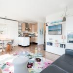 Apartment with kitchen, dining area, and living room. Sofa, TV, and glass table are visible.