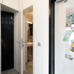 Entrance area with view into bathroom and coat hooks on the door.