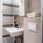 Bathroom with sink, mirror, and towel radiator.