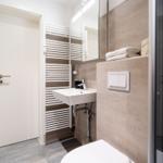 Bathroom with sink, mirror, heater, and shower.