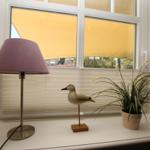 On the windowsill are a lamp, a bird figurine, and a plant.