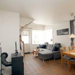 Wohn- und Essbereich mit Sofa, Esstisch und Treppenaufgang.