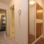Flur mit Spiegel, Garderobe und Blick in Bad und Schlafzimmer