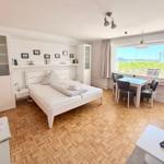 A bedroom with harbor view. It has a bed, a table and a TV.