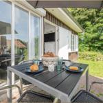 Terrasse mit Tisch, Stühlen und Brot. Hintergrund: Grünfläche und Haus.