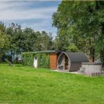Haus mit Sauna, Whirlpool und Spielplatz auf grünem Grundstück.