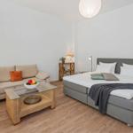 A bedroom with a bed, a sofa, and a table.