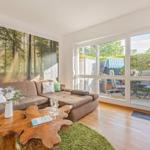 Living room with sofa, wooden table, and view of the terrace.