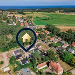 Haus in grüner Umgebung mit Blick auf Meer und Wiesen.