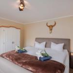 Schlafzimmer mit Bett, Kleiderschrank und Wanddekoration.