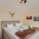 Schlafzimmer mit Bett, Nachttisch und Wanddekoration.