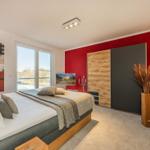 Schlafzimmer mit Bett, Fenster, Kleiderschrank und Wanddekoration.