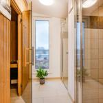 Dusche mit Glaswand, Sauna und Fenster mit Blick nach draußen.