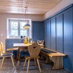 Dining room with wooden table, benches, and blue cabinets along the wall.