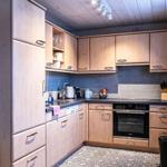 Kitchen with wooden cabinets, stainless steel sink, and built-in oven.